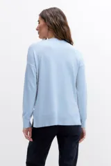 Sweater de tejido liso color celeste claro, con escote en V y mangas largas.