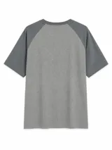 Remera de estilo raglán con cuerpo en gris claro y mangas en gris oscuro. Presenta cuello redondo y diseño de manga corta.