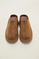 Zueco tipo mule de gamuza color camel, con plataforma de goma al tono y costura central decorativa.
