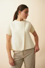 Chaleco color beige con textura tipo espiga, corte holgado y solapa cruzada.