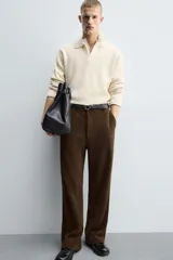 Pantalón de corte wide fit confeccionado en pana de algodón color marrón oscuro. Presenta bolsillos frontales, bolsillos traseros de vivo con botón y cierre frontal con cremallera y botón.