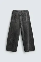 Jeans de denim de algodón, color azul oscuro con efecto lavado. Presentan un corte muy holgado (baggy fit) en toda la pierna y tiro medio. Tienen cinco bolsillos y cierre frontal con cremallera y botón.