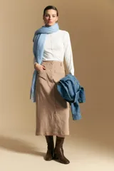 Maxifalda midi de pana color beige, de tiro alto, con abotonadura frontal completa y bolsillos aplicados en el frente.