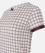 Blusa de pijama de cuello redondo y manga corta, confeccionada en tejido peach touch color blanco con estampado geométrico de corazones en tono bordó. Cuenta con detalles de encaje en los puños y un pequeño moño decorativo en el escote.