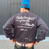 Buzo de algodón gris oscuro, corte holgado, con estampado en la espalda que incluye el logo de Nude Project y frases como "Respected Locally, Known Globally" y "By Artists For Artists Est. 2019".