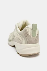 Zapatilla deportiva estilo running con combinación de materiales y detalles en tonos verdes. Presenta puntera redonda, tirador trasero y suela con relieve.