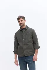 Sobrecamisa de canvas color beige con efecto lavado, de estructura firme y manga larga. Presenta cuello clásico, cierre frontal con botones y un bolsillo frontal en el pecho.