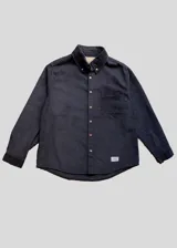 Camisa de pana gruesa color azul marino, de corte recto, con cuello abotonado, manga larga y bolsillo en el pecho. Cierre frontal con botones color madera.