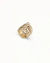 Anillo de diseño multicapa en tono dorado, compuesto por varias bandas unidas que presentan detalles en forma de cabeza de clavo. Pieza artesanal con acabado pulido.