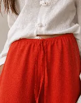 Pantalón rojo de corte holgado, estilo bombacho, con puños fruncidos en los tobillos.