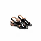 Sandalias de cuero charol negro con tiras cruzadas en el empeine, pulsera ajustable al tobillo con hebilla metálica dorada, taco ancho efecto madera y suela tractorada.