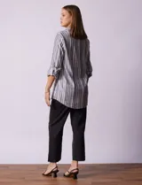 Camisa de lino a rayas grises, blancas y negras, con cuello clásico, escote en V, abertura frontal con botones y bolsillo de parche en el pecho.