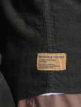 Camisa de pana color azul marino, con mangas largas, cuello clásico y dos bolsillos frontales con solapa y botón.