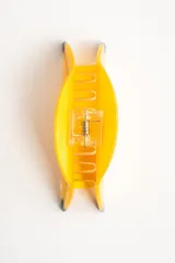 Broche para el pelo en forma de banana, color amarillo con detalles en negro, fabricado en acetato.