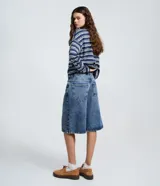 Bermuda jorts de jeans azul, corte ancho y largo por debajo de la rodilla, tiro medio con trabillas para cinturón y bolsillos traseros.