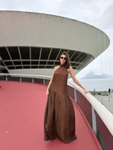 Vestido largo marrón de crepe texturizado, con cuello halter fruncido, diseño holgado y falda larga con vuelo.