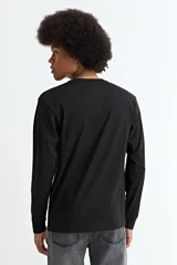 Remera de manga larga con cuello redondo, confeccionada en tejido de algodón y poliéster, con diseño básico y ajuste estándar.
