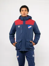 Parka de abrigo Umbro del Club Nacional de Football, con diseño de bloques de color en azul, rojo y blanco. Cuenta con capucha, cierre frontal, bolsillos frontales y el escudo del club bordado en el pecho.