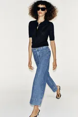 Jeans culotte de tiro alto, color azul, con pernera ancha, nervios marcados en el delantero y bolsillos de parche con botones metálicos. Cuenta con cierre frontal de cremallera y botón metálico.
