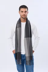 Bufanda tejida con diseño de cuadros en tonos grises, negros y azules, con terminación de flecos en los extremos.