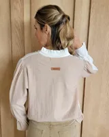 Blusa de algodón con cuello mao y volados, mangas largas con puños elásticos y corte holgado.