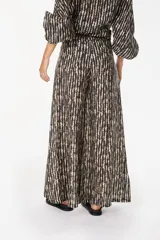Pantalón de lino italiano con diseño estampado a rayas verticales en tonos negro y beige, de tiro medio y corte ancho.