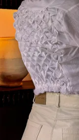 Camisa corta color rojo con escote en V y mangas largas acampanadas. Presenta ajuste frontal con lazos.