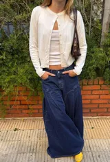 Jean ancho azul de corte wide leg, con diseño de costuras curvas decorativas en la parte delantera y tiro bajo.