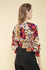 Top corto de viscosa con estampado floral, escote en V, mangas 3/4 con puños elastizados y ruedo trasero elastizado.