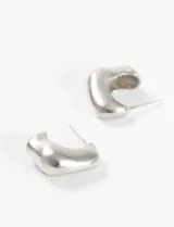 Aros tipo argolla plateados, gruesos e irregulares, de 2 cm de diámetro.