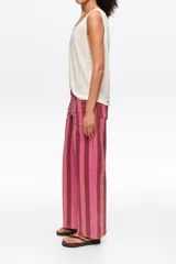 Pantalón de jean de corte recto con diseño de rayas verticales en tonos rosados y bordó.