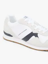 Championes de diseño runner de Tommy Hilfiger, confeccionados en una combinación de textil y cuero en color blanco, con detalles en gris claro, azul marino y suela de goma color caramelo.