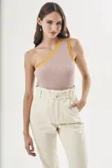 Top tejido color crema con rayas verticales y ribete amarillo en el escote asimétrico.
