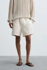 Bermuda relaxed fit confeccionada en tejido ligero de cáñamo. Presenta cintura elástica ajustable con cordón interior, bolsillos laterales y un bolsillo trasero de plastrón con solapa.