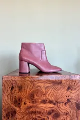 Botas de cuero color borratinto, con taco ancho y caña corta, punta redondeada y diseño minimalista.