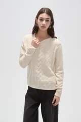 Sweater de punto color natural con diseño de ochos, cuello redondo y mangas largas de calce holgado.