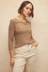 Remera marrón de manga tres cuartos, cuello a la base y costuras marcadas en los hombros. De un textil elastizado, súper cómoda y ceñida al cuerpo.