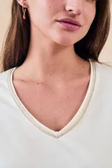 Remera de algodón color mostaza, de manga corta y escote en V con detalle metalizado.