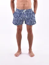 Short de baño azul con estampado de hojas blancas, cintura elástica con cordón blanco ajustable y bolsillos laterales.