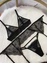 Conjunto de lencería compuesto por bralette triangular, tanga y portaligas, confeccionado íntegramente en encaje negro con detalles de breteles regulables.