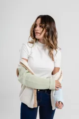 Cárdigan de punto color crema con mangas largas y terminaciones en color naranja y lila. Posee cuello en V y cierre frontal con botones color madera.