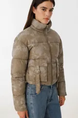 Campera puffer corta color verde con estampado difuminado, cierre frontal con cremallera, cuello alto y bolsillos con solapa y hebilla.