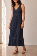 Vestido largo de lino azul marino, sin mangas, con escote en V y corte en la cintura. Presenta costuras pespunteadas a la vista y falda amplia con vuelo.