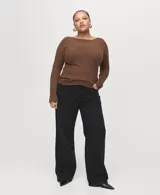 Pantalón de jean negro de corte recto y tiro alto, con diseño clásico de cinco bolsillos y cierre frontal con botón y cremallera.