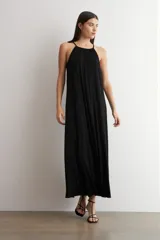 Maxi vestido negro de lurex con cuello halter, sin mangas y diseño fluido de corte largo.