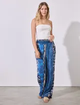 Pantalón largo de rayón con estampado floral en tonos azules y blancos. Tiene pretina ancha elastizada con punto smock.