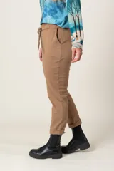 Pantalón negro de tela agamuzada, corte cigarette, con cintura elastizada ajustable con cordón y bolsillos laterales.