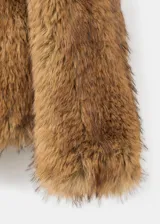 Chaqueta de efecto pelo sintético color marrón, con solapas amplias y diseño de manga larga sin cierre.