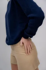 Sweater gris de tejido de punto, con cuello redondo y mangas largas.