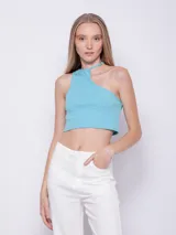 Top corto blanco de punto, sin mangas, con cuello halter asimétrico.